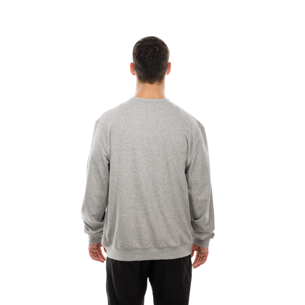A man viewed from behind wearing a light gray heather crewneck sweatshirt and black pants, standing against a solid white background.