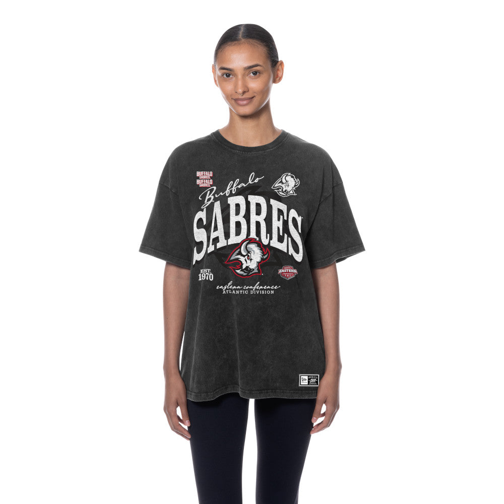 A woman modeling a dark washed charcoal gray Buffalo Sabres graphic t-shirt against a plain white background.