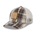 Plaid patterned cap with a brown patch on a white background