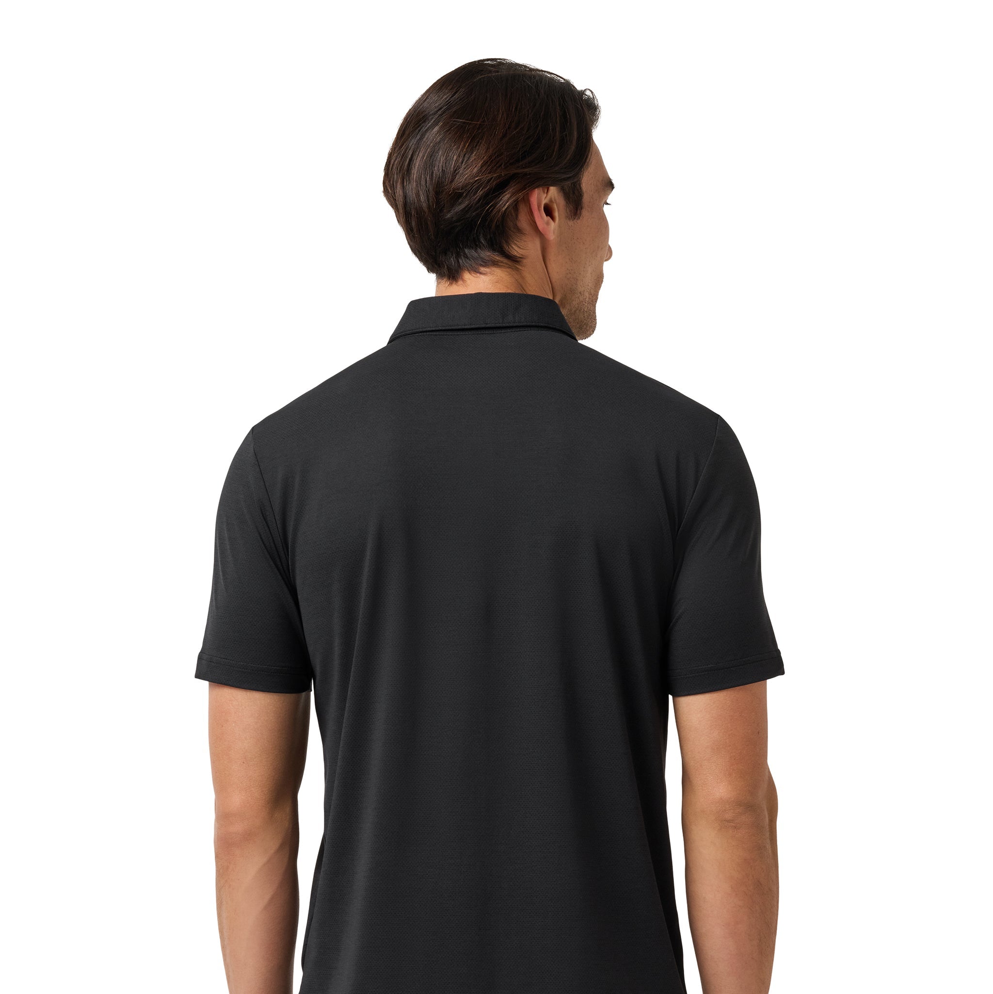 A man viewed from the back wearing a black short-sleeve polo shirt and black pants against a plain white background.