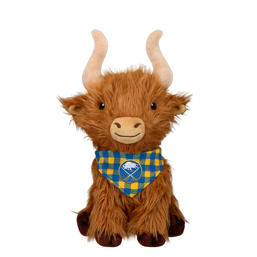 A plush Highland cow toy with long brown fur, cream horns, and a blue and yellow plaid bandana featuring a white buffalo logo, set against a plain white background.