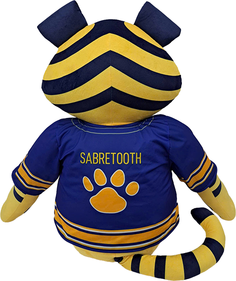 A plush mascot toy shown from the back, featuring a blue and yellow striped cat-like head with ears, a blue body, and a blue shirt printed with the word 'SABRETOOTH' and a yellow paw print. The toy has yellow and blue striped arms and tail, photographed on a plain white background.